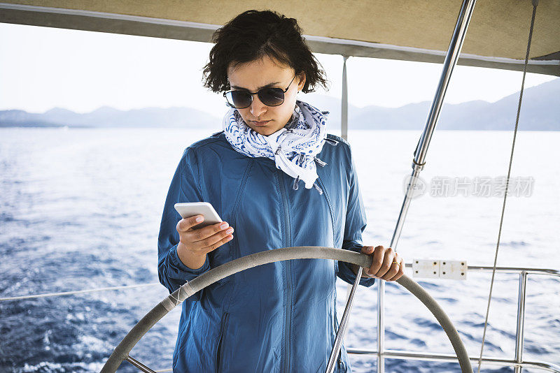 Woman sailing, using her phone